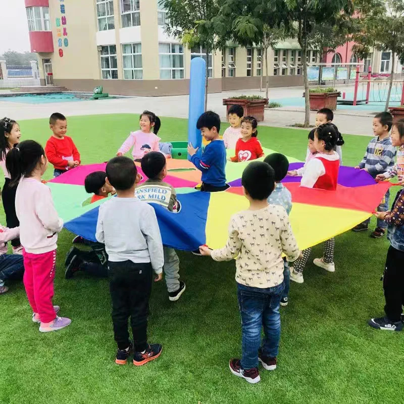 I bambini all'aperto giocano con la tenda del giocattolo dell'arcobaleno del paracadute giochi per bambini parco giochi per l'asilo divertimento delle attività di Team Building della cooperazione