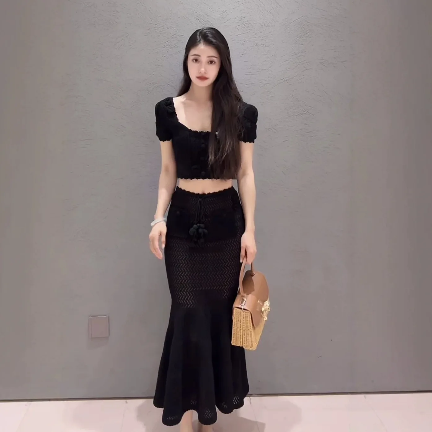 

Women's black knitted two-piece suit with puff-sleeved T-shirt top or slim-fitting mid-length skirt