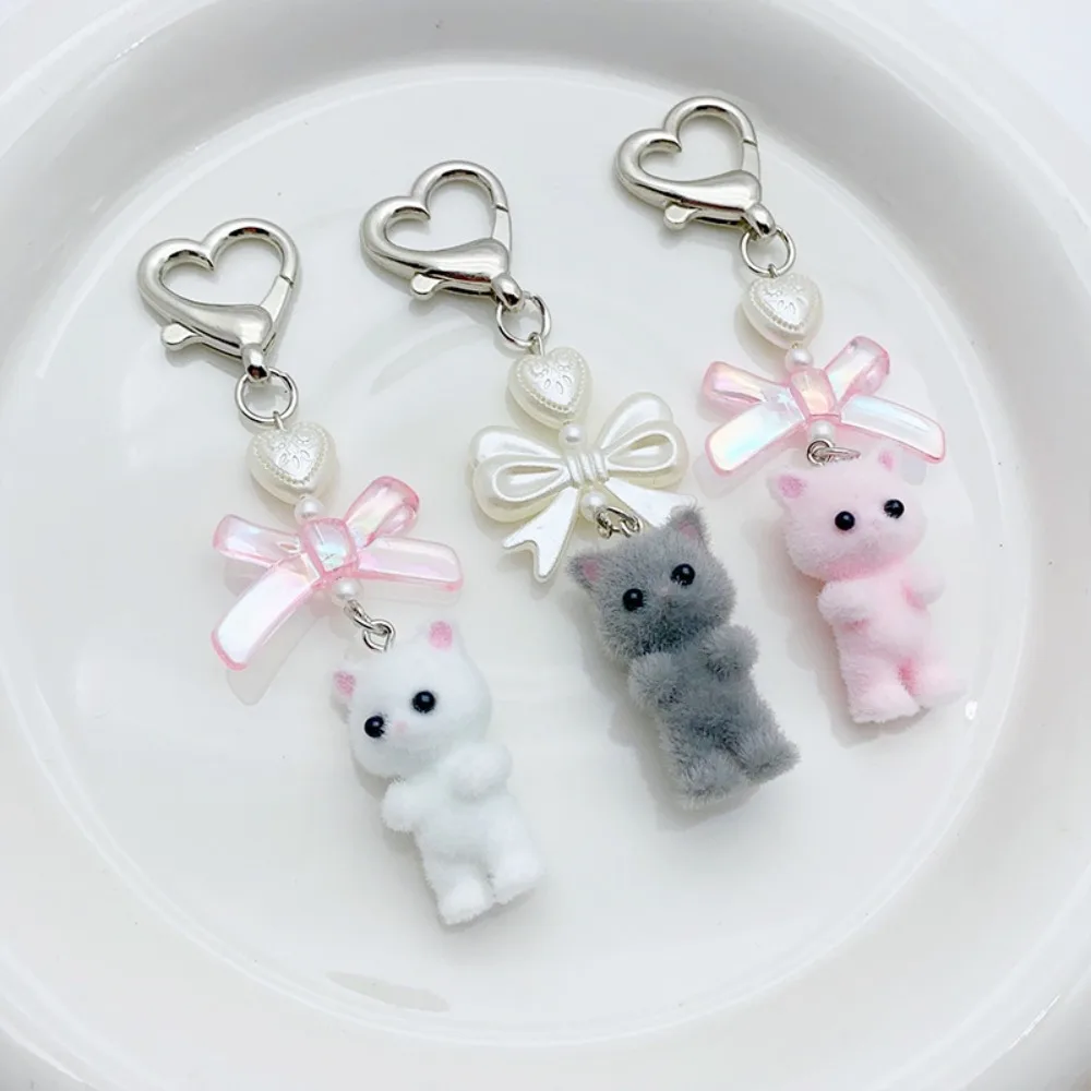 Simpatico portachiavi con fiocco a forma di cuore con gatto sfocato, bambola di gatto di peluche, fiocco Kawaii, portachiavi con cuore di perle, zaino, ciondolo per borsa da donna