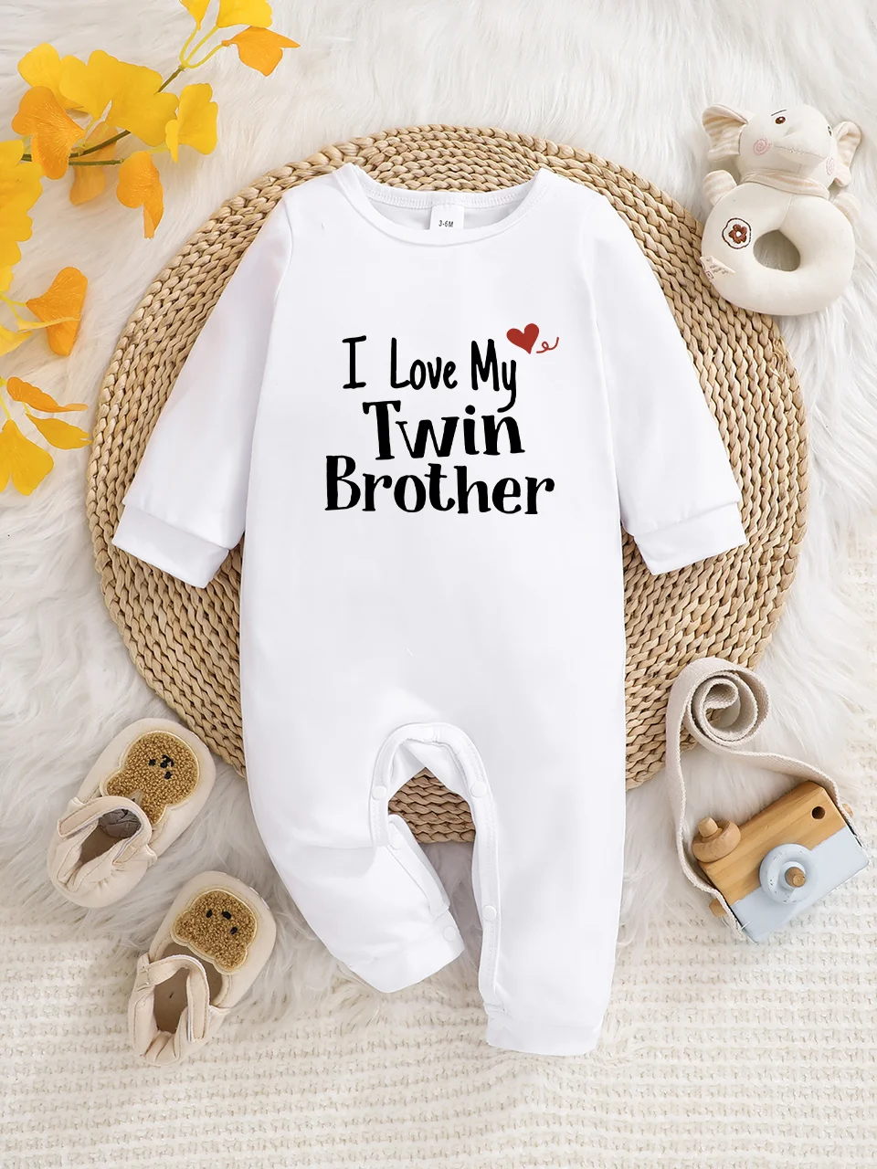 A baby long-sleeved onesie with interesting letter prints. It features a buttoned design for easy putting on and taking off, and