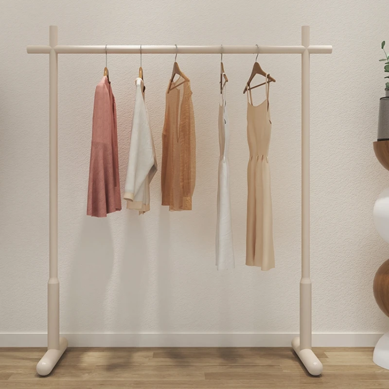 The clothes hanger is foldable on the ground, and there is a small space with cream air in the bedroom for cool drying