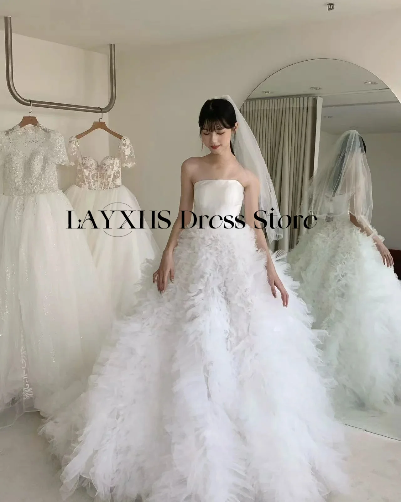 ชุดแต่งงานสีขาวแบบไร้สายหรูหรา ทรงเอไลน์ สไตล์เกาหลี-ญี่ปุ่น ผ้าซาตินและผ้าทูลล์ สำหรับถ่ายภาพ ชุดเจ้าสาวสั่งตัดได้ รุ่นใหม่ล่าสุดปี 2026