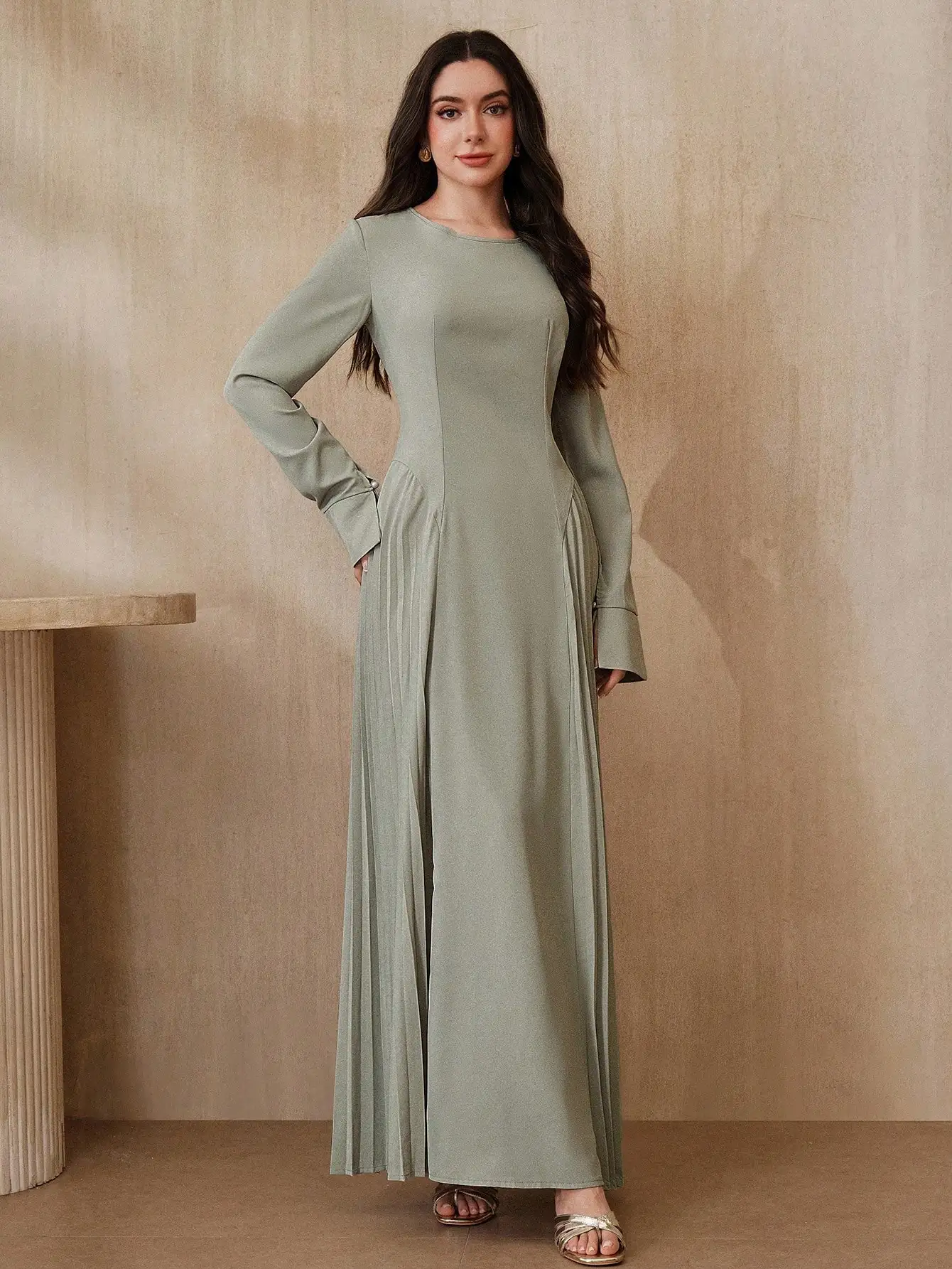 

Элегантное однотонное длинное платье цвета шалфейной зелени с длинными рукавами, скромного фасона, длиной в пол.