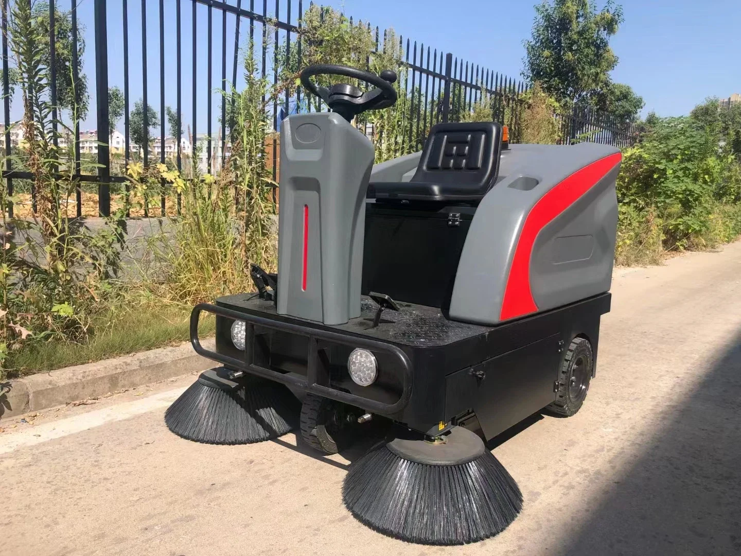 Equitazione su un pulitore per pavimenti in strada, pulitore stradale, aspirapolvere industriale