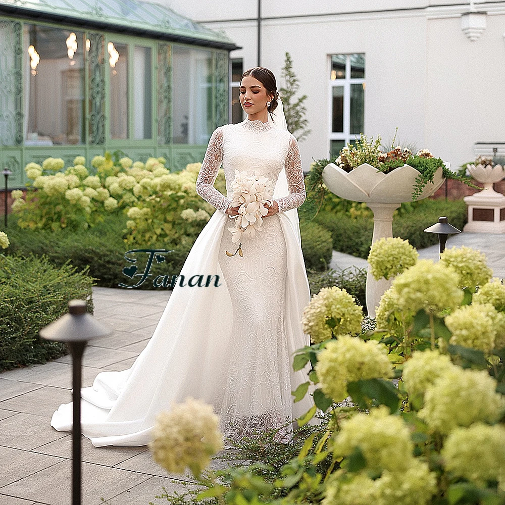 Suknia ślubna z białej koronki z dekoltem w kształcie litery O, z iluzorycznymi, długimi rękawami, trenem Watteau, długości do podłogi, o kroju syreny.