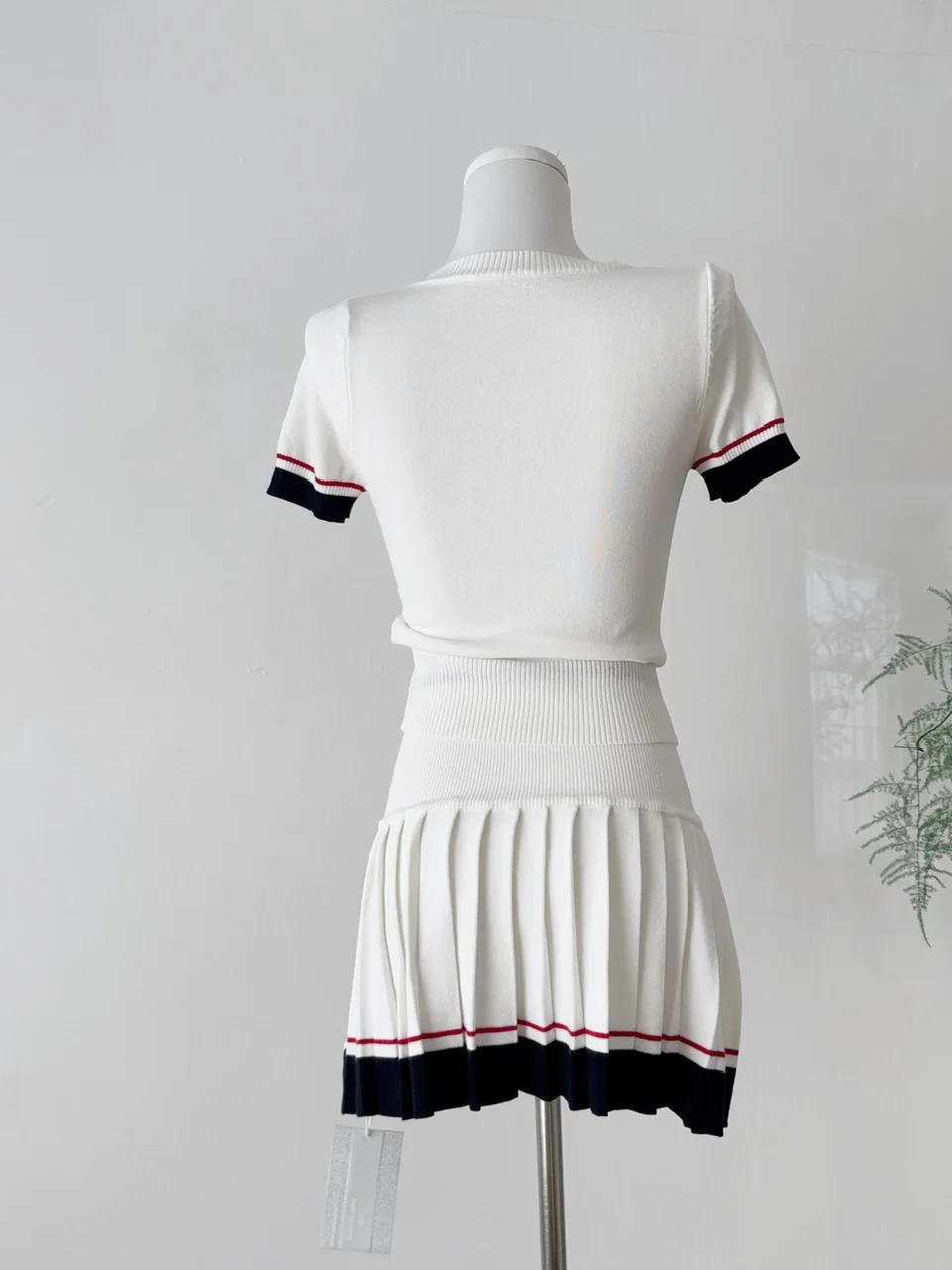 Setelan Dua Potong Slim Fit Musim Panas Wanita dengan Rok Lipit dan Kaos Rajut Elastis Putih Retro Amerika.