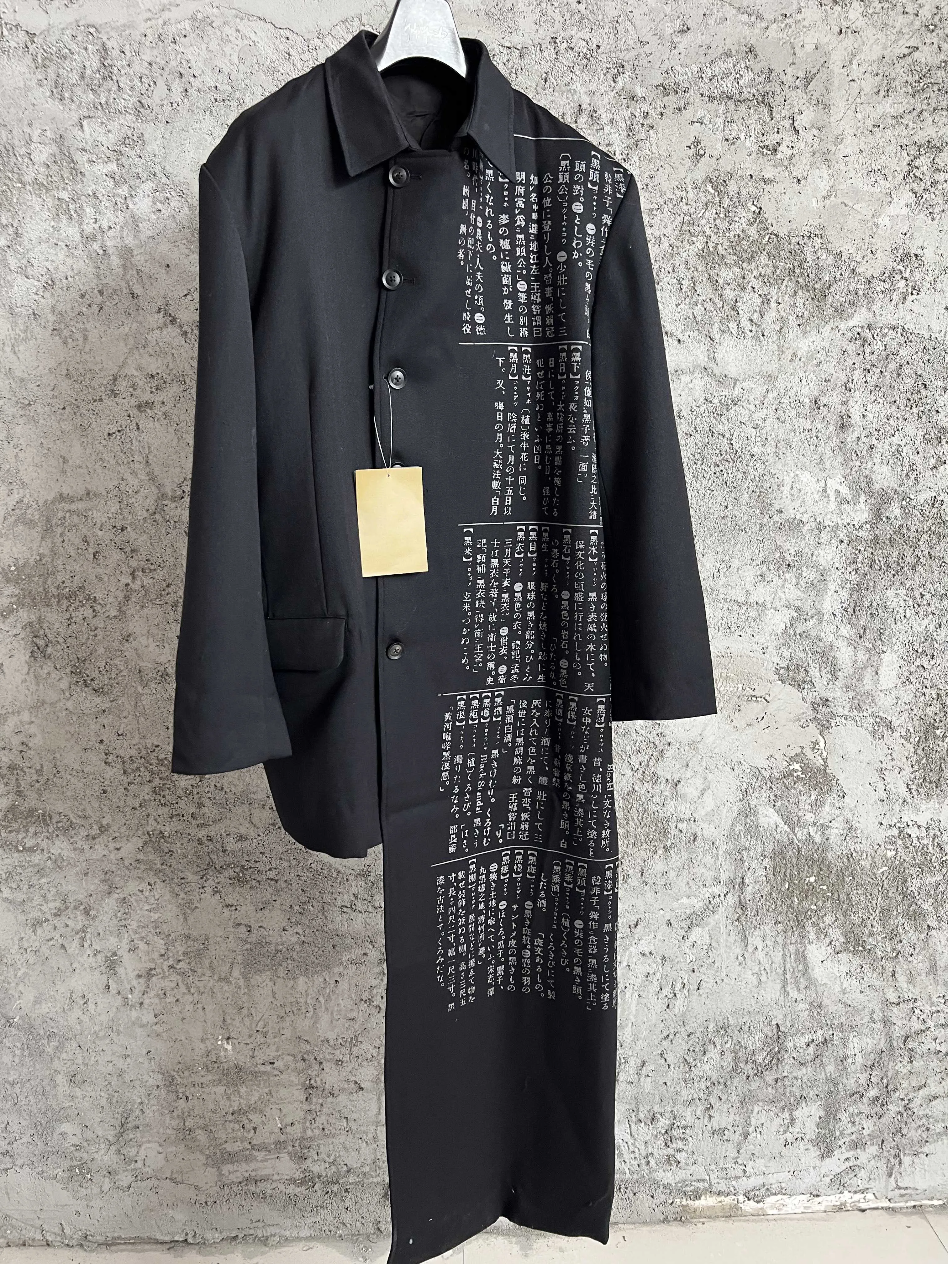 

Dictionary discharge printing, wool coat, asymmetrical black overcoat