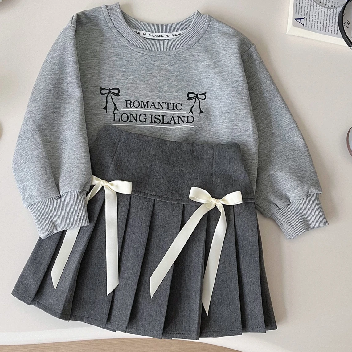 Komplet ubrań dla dzieci na jesień i zimę 2025, nowy styl koreański, dziewczęcy, w stylu zagranicznym, bluza z kapturem z kokardą, słodka krótka spódniczka, dwuczęściowy zestaw.