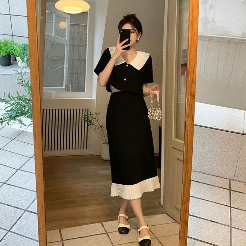 

Женский комплект из двух предметов: свободная блузка с V-образным вырезом и коротким рукавом, юбка миди А-силуэта с цветовыми блоками, модный наряд