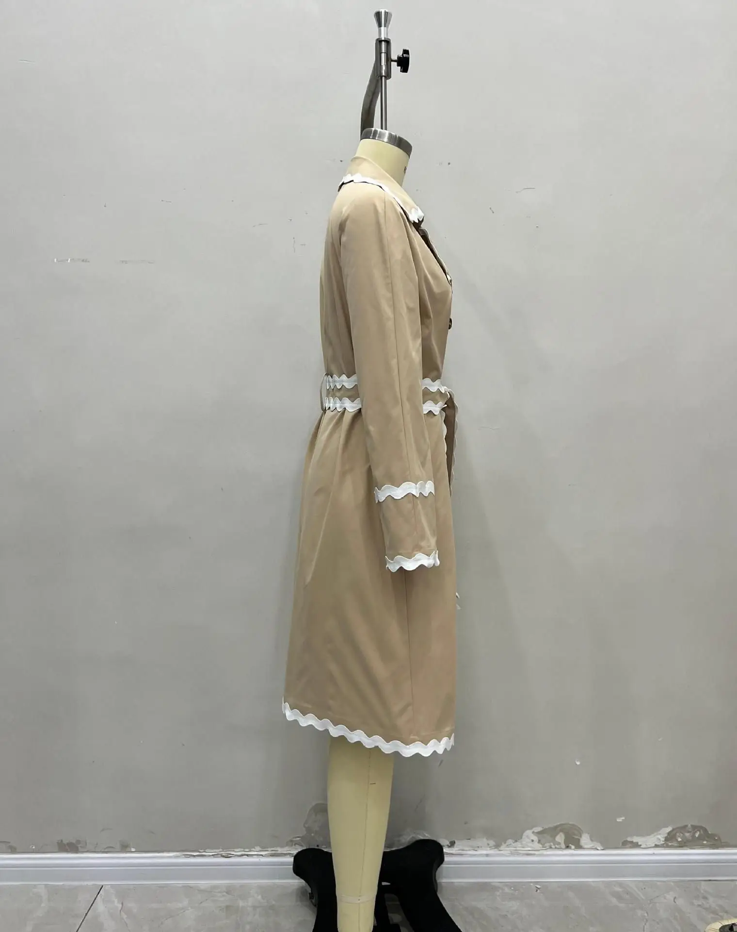 Biała marynarka z plisowanym kołnierzykiem, dwurzędowym zapięciem i podkreśloną talią oraz dwurzędowym zapięciem z przodu.