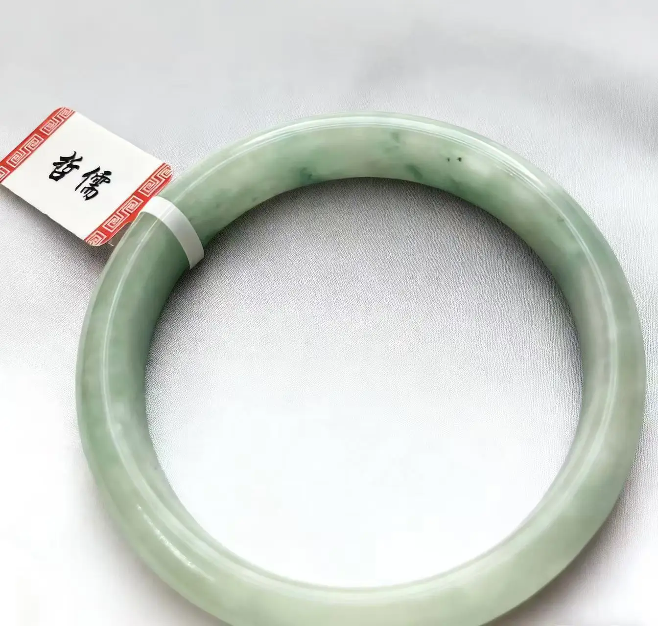 

Настоящий телефон съемки светло-зеленого нефритового браслета диаметром 52,9 мм.