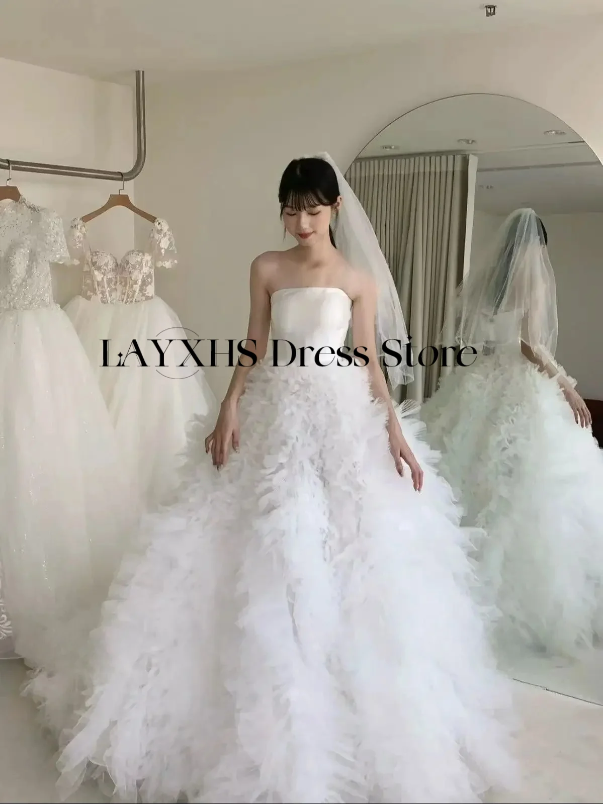 ชุดแต่งงานสีขาวแบบไร้สายหรูหรา ทรงเอไลน์ สไตล์เกาหลี-ญี่ปุ่น ผ้าซาตินและผ้าทูลล์ สำหรับถ่ายภาพ ชุดเจ้าสาวสั่งตัดได้ รุ่นใหม่ล่าสุดปี 2026