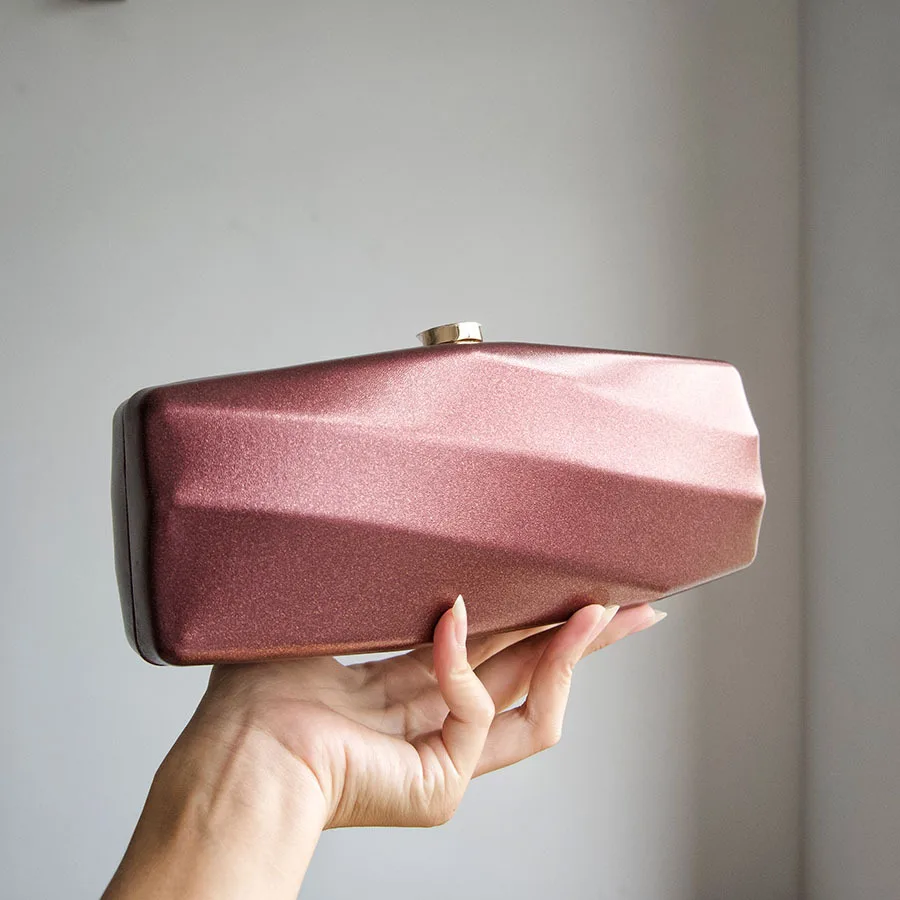 Bolso de cena rígido con forma angular, textura de corte tridimensional, bolso de mano sencillo y elegante con acabado nacarado y brillo fino.