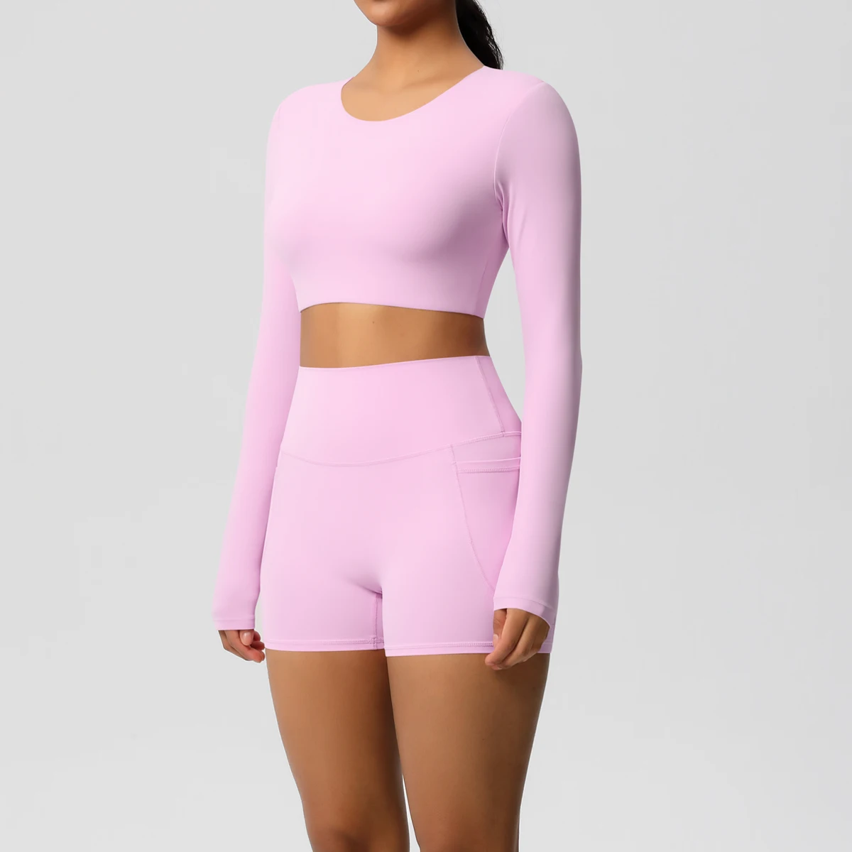 ชุดโยคะผู้หญิง ชุดออกกำลังกาย สีพื้น ทรงเข้ารูป แขนยาว แห้งเร็ว กางเกงขาสั้นฟิตเนสทรงพีชบัตต์เทิ้ล มีกระเป๋า
