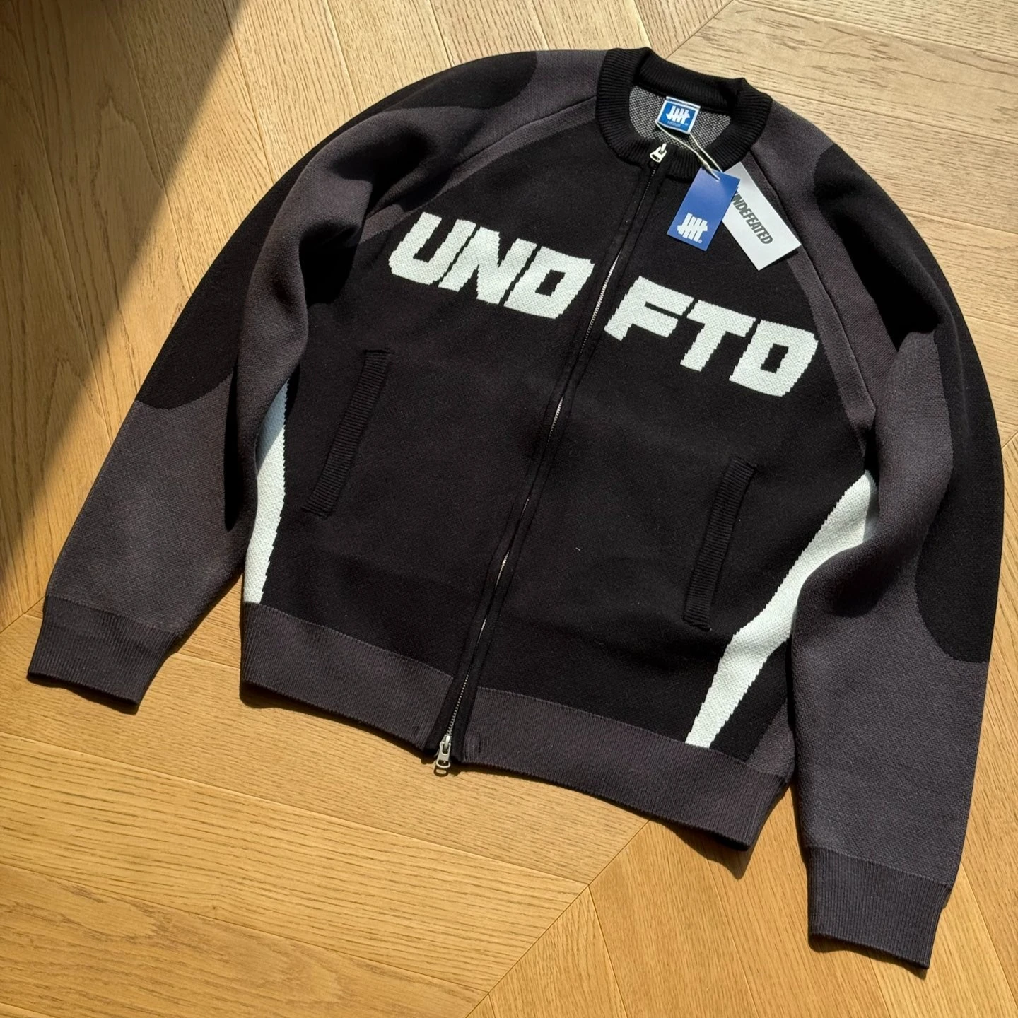 UNDEFEATED FW26 Racing Colorblock Jacquard Zip-Up Sweater | Unisex Drop-Shoulder Knit Cardigan | Streetwear Fall Outerwear