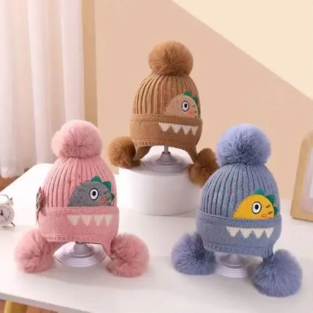 

New Cartoon Dinosaur Knitted Hats with Earflap Fur Ball Woolen Hat Ear Protection Fleece Lining Toddler Bonnet Hats Winter