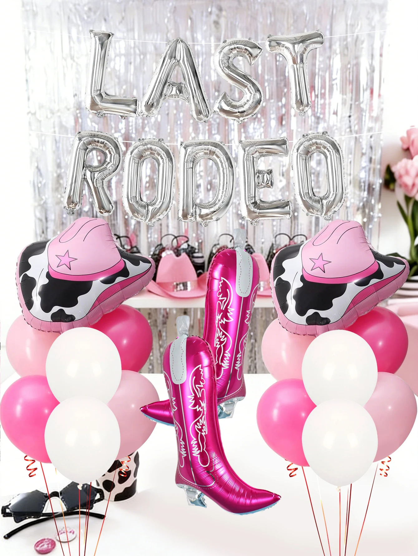 Este set de globos de vaquero de 28 piezas incluye un cartel de globos plateado con la inscripción LAST RODEO, botas, un globo de aluminio con forma de sombrero de vaquero, y globos rosas y blancos.