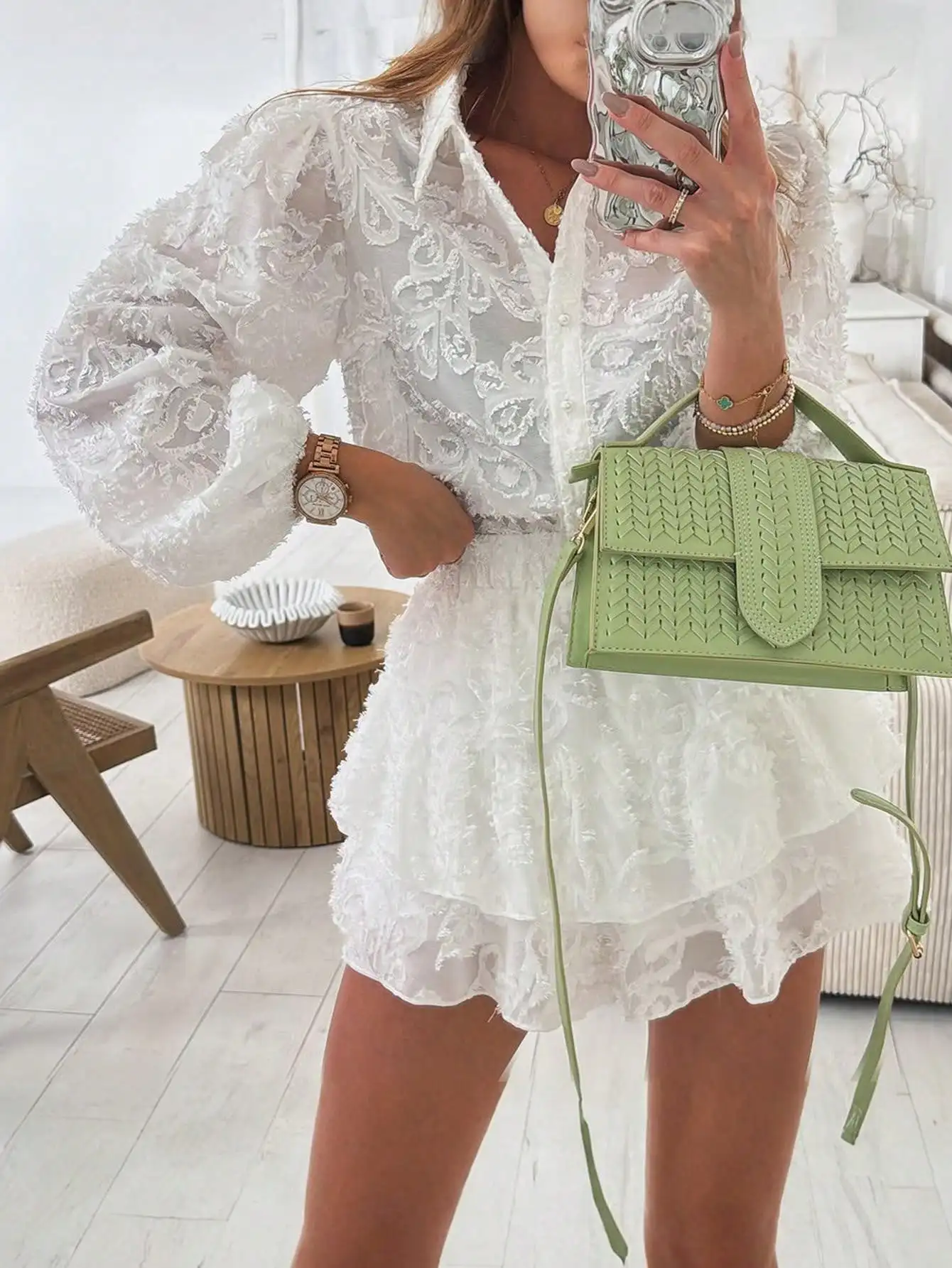 

Женский комплект: белая прозрачная кружевная блузка с длинными рукавами на пуговицах и мини-юбка с рюшами по низу