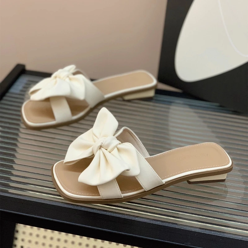 

2025 новые тапочки с бантом, женская летняя одежда, новые модные милые нескользящие тапочки на плоской подошве для девочек, крутые женские тапочки Fairy Wind Word