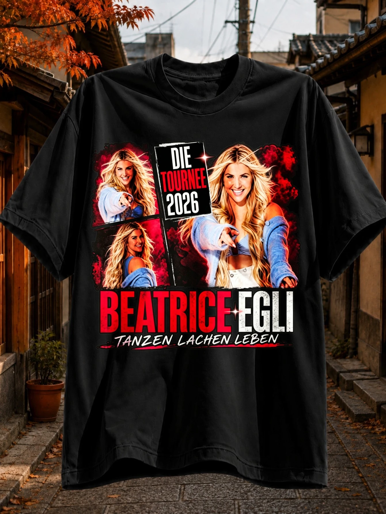 T-shirt avec collage de photos et textes imprimés "Beatrice Egli", "Die Tournee 2026" et "Tanzen Lachen Leben" en rouge et noir gras, style concert.