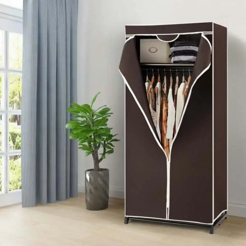 Armoire textile simple couleur café avec housse anti-poussière. Structure en tubes métalliques antirouille sans outils pour le montage. Fermeture à glissière, barre de suspension pour vêtements et rangements supérieurs et inférieurs. Dimensions 74 × 50 × 172 cm, légère et stable