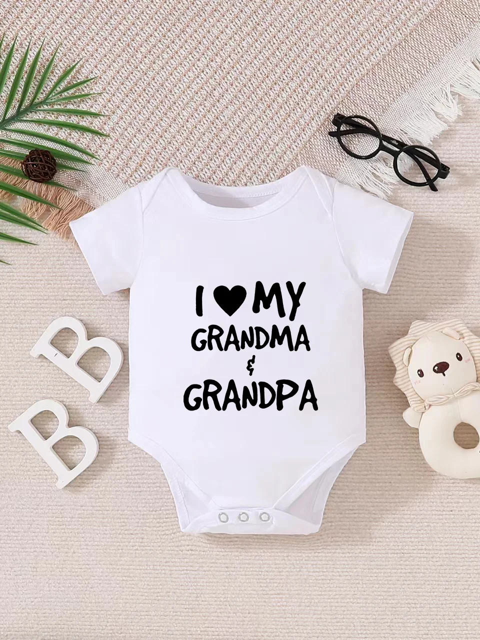 Playful letter-printed baby short-sleeve triangle bodysuit. Button closure for easy dressing, machine washable