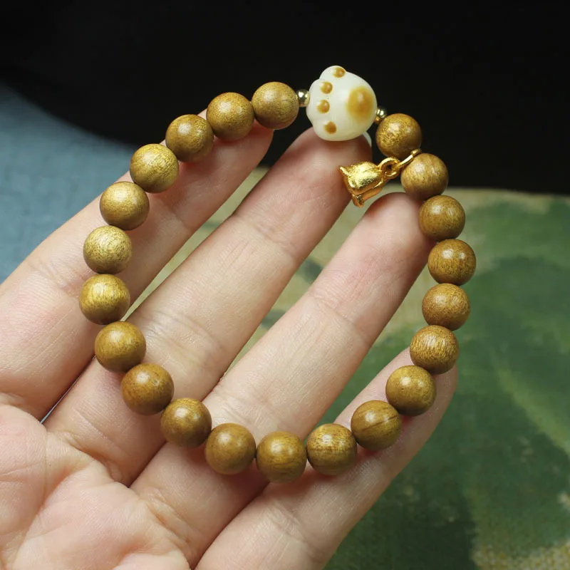 8mm old golden nanmu wood bracelet with carbon-burned cat paw and lily of the valley designs, unisex Buddhist beads in a forest