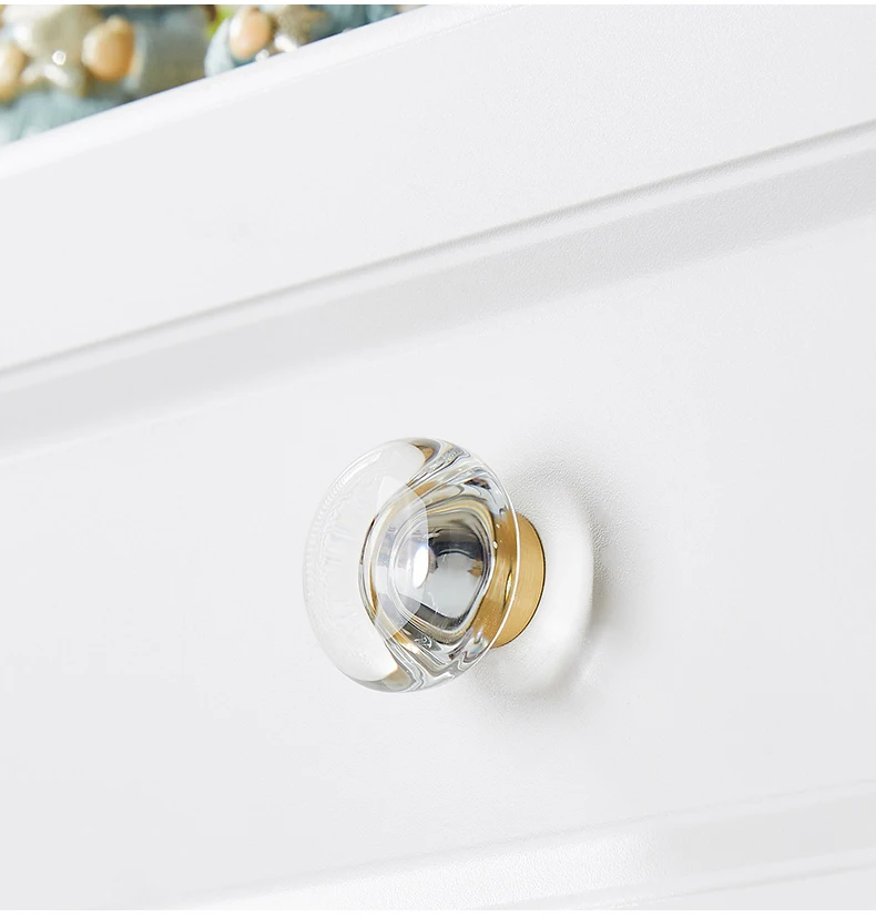 Clear ribbed glass knob shown against white furniture