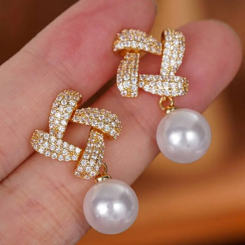 Huitan Elegante Tropfenohrringe für Damen, Kreuzknoten-Design, eingelegt mit glänzendem CZ, zarte Imitationsperlen-Accessoires, Modeschmuck