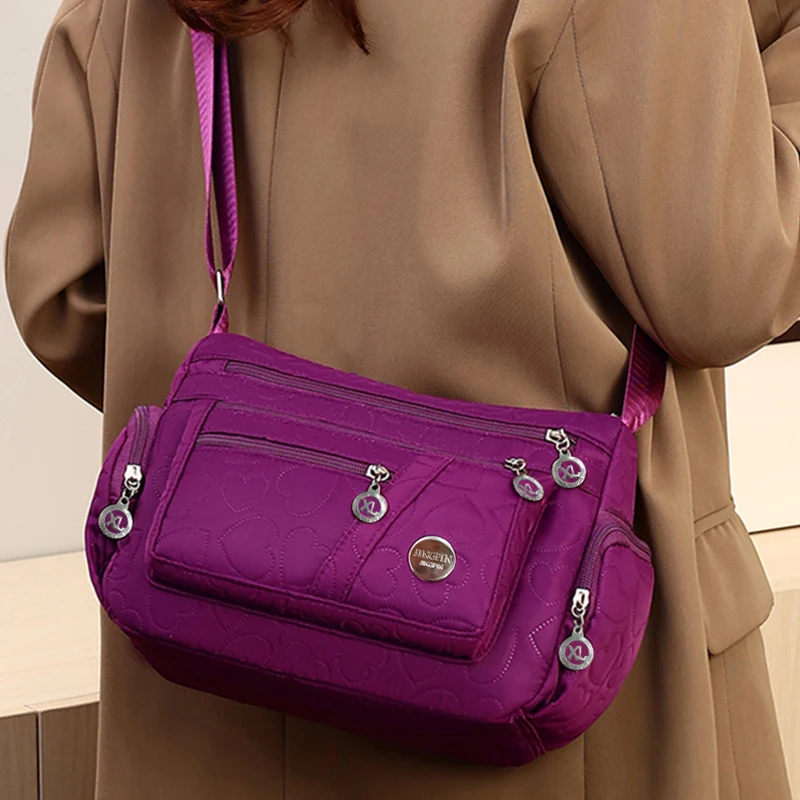 Schicke, verzierte Damen-Umhängetasche für den täglichen Pendelverkehr. Stilvolle, leichte, lässige Nylontasche mit Herzdetail und mehreren Taschen – Detail 9