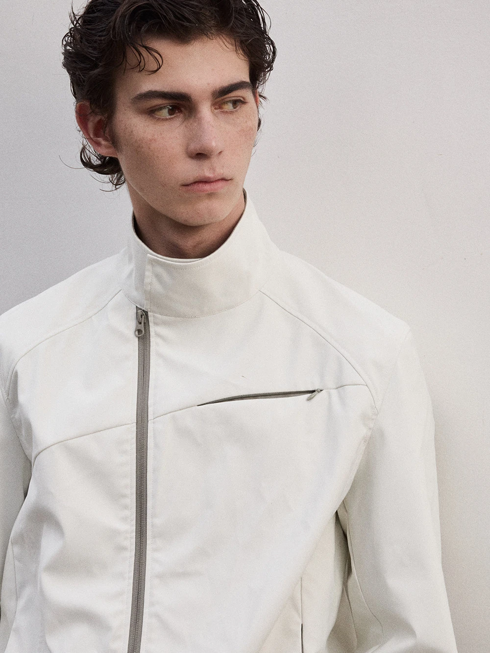 Unisex jacket with foldable sleeves, slanted zipper, and stand-up collar