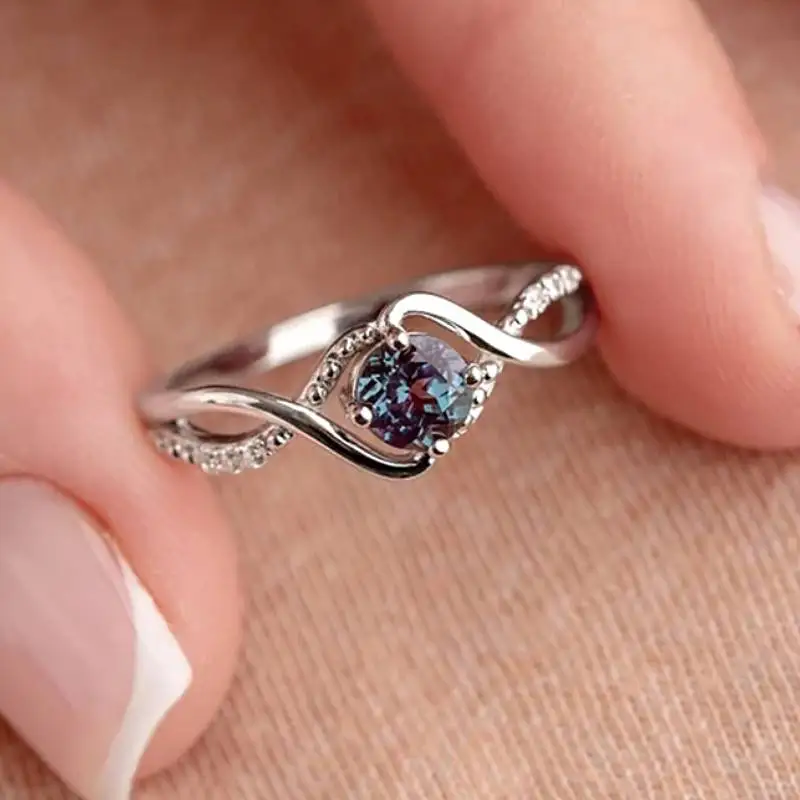 Huitan Eleganter Damenring mit gedrehtem Design, eingelegt mit funkelndem blauen CZ, modisch, für Partys, Verlobungen, edle Damen-Accessoires, zarter Schmuck