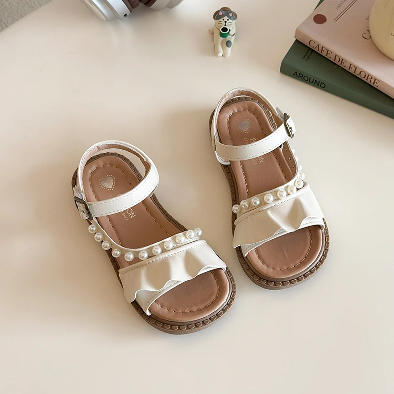 

Детские кожаные сандалии на ремешках с блестящими бусинами, новинка 2026 года, летние пляжные сандалии для девочек, нескользящие, модные, для принцесс, для вечеринок, на плоской подошве