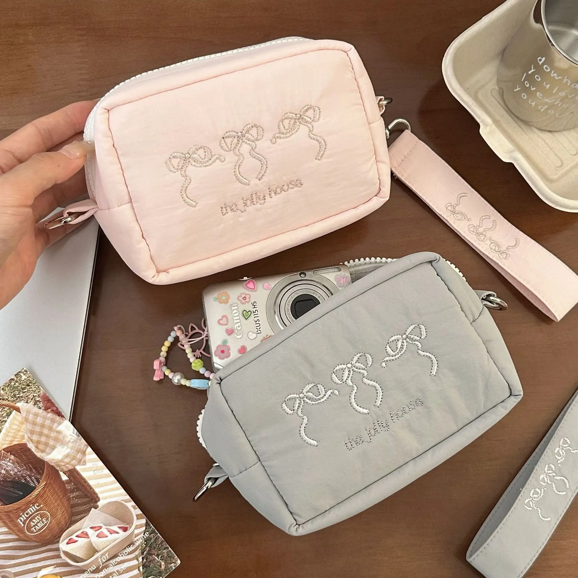 A simple camera storage bag with anti-drop function, thick material, portable and women's embroidered bow wrist bag for storage.