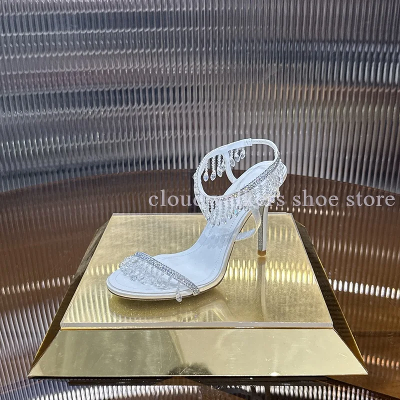 

Белые кожаные сандалии с кристаллами и кисточками, модные вечерние туфли на шпильке, римские сандалии с открытым носком, сексуальные сандалии с бусинами на щиколотке