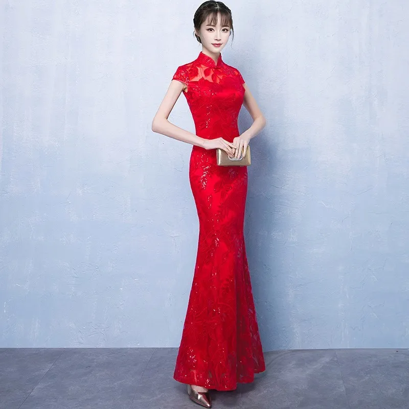 A in long red form-fitting toasting dress modified cheongsam for performance etiquette and female host welcoming guests