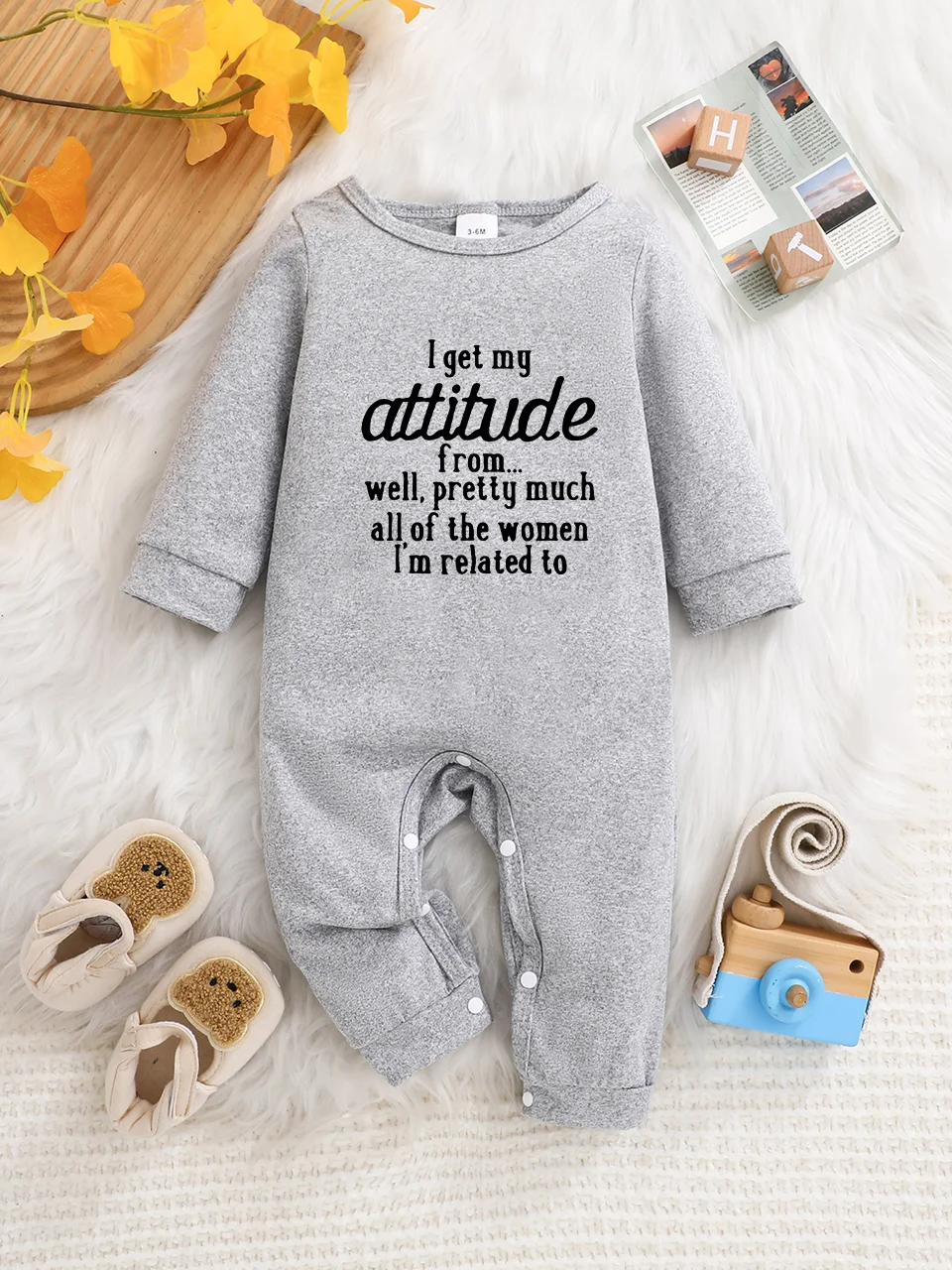 A baby long-sleeved onesie with interesting letter prints. It features a buttoned design for easy putting on and taking off, and