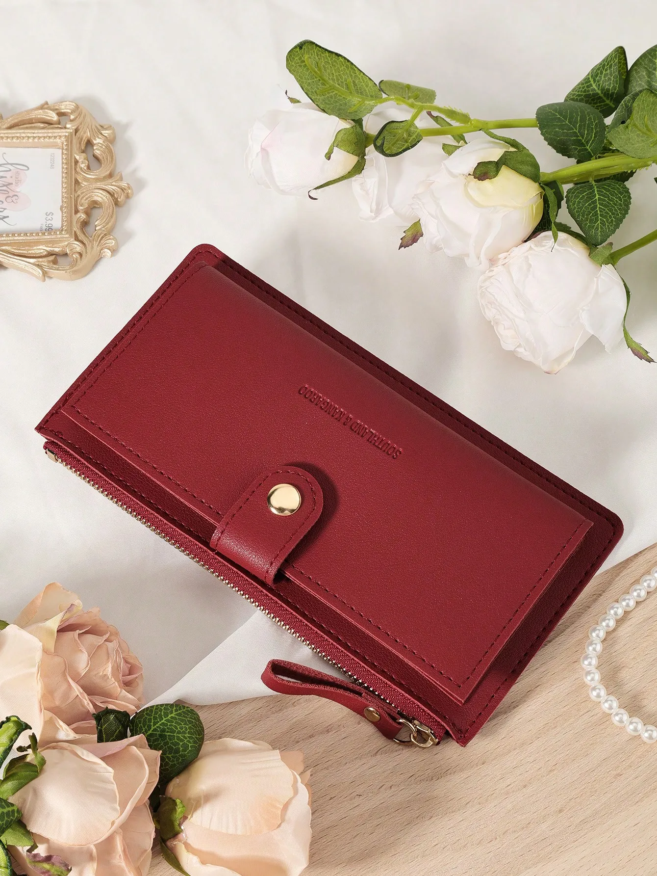 

Длинный кошелек бордового цвета с застежкой-кнопкой и отделением на молнии