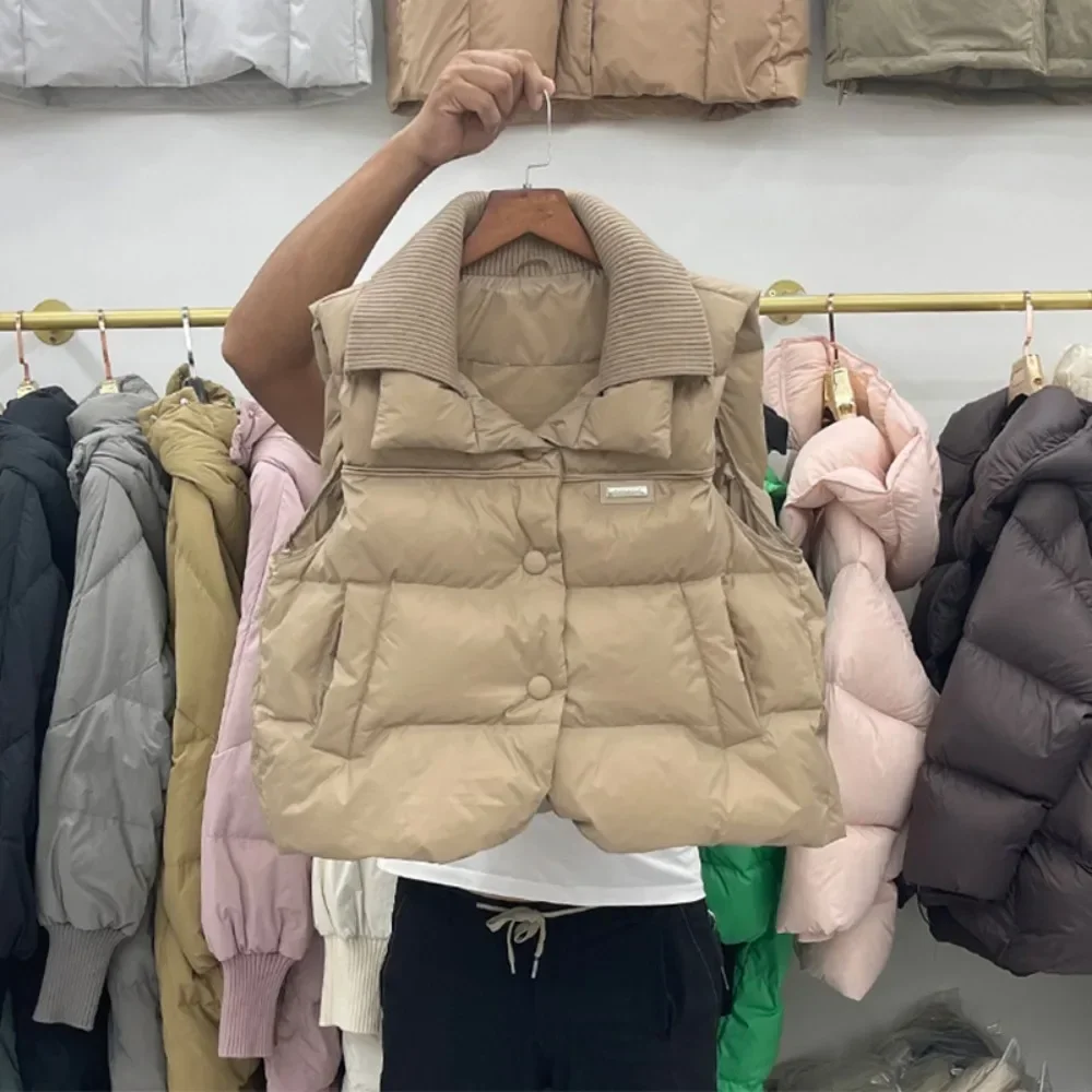 เสื้อกั๊กคอปกสองชั้นเย็บติดกัน รุ่นใหม่ประจำฤดูหนาวปี 2025 เสื้อโค้ทขนเป็ดสีขาวสำหรับผู้หญิง เสื้อกั๊กแฟชั่นแขนกุดแบบสั้น อุ่นสบาย