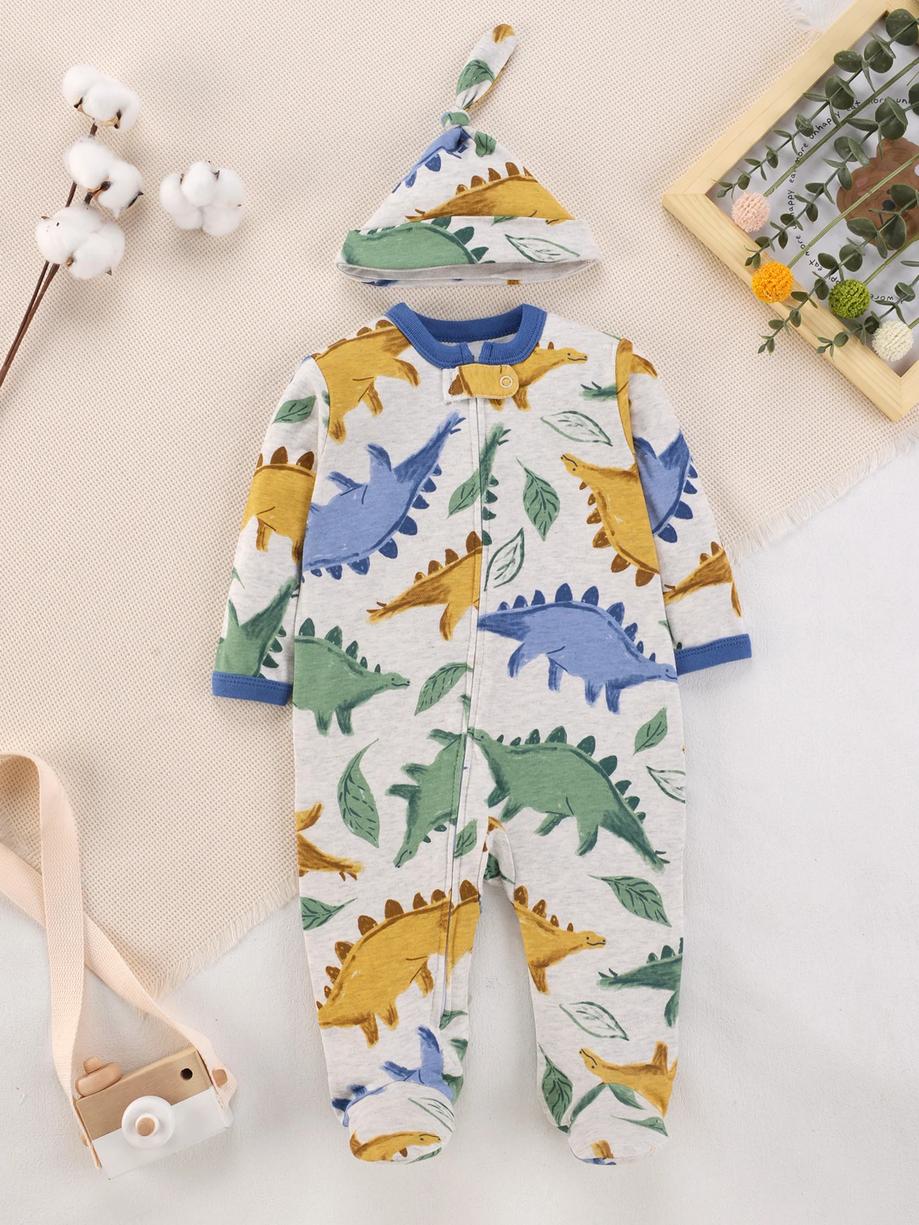 Grauer Baby-Strampler mit Dinosaurier-Print, weicher Baumwoll-Strampler mit Reißverschluss und passender geknoteter Mütze für neugeborene Jungen, ganzjährig tragbar.