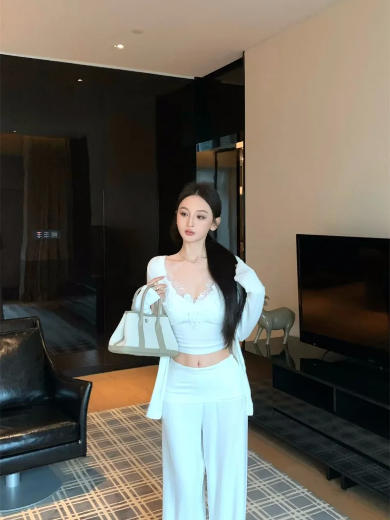 

Комплект из трех предметов: Жилет без рукавов с кружевными вставками Pure Desire, длинный кардиган с открытыми рукавами и повседневные широкие брюки. Женский зимний белый комплект.