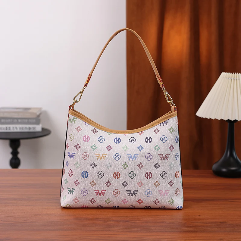 Women's Tote Underarm Bag, colorful letter print all-over monogram crescent tote bag, decorated with a bow tag, featuring a short underarm shoulder strap + adjustable long crossbody strap dual-strap design, zippered closure with large capacity interior, fresh and fashionable style, dimensions 30×24×9cm, versatile shoulder and crossbody bag for daily commuting, shopping, and travel