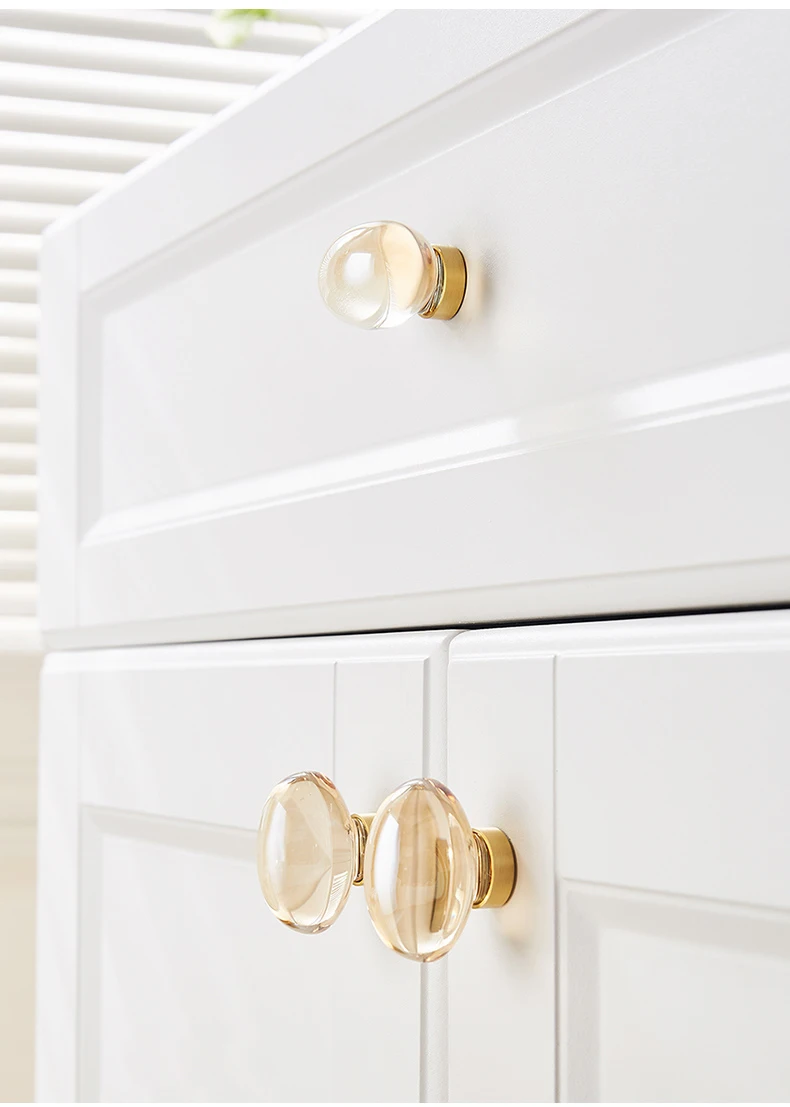 Champagne oval glass knobs on a white cabinet