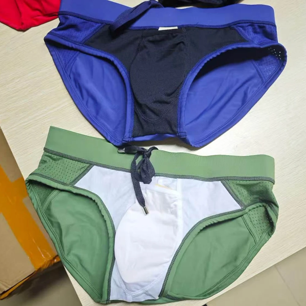 2026 Novedad transfronteriza: Bañador de hombre de color liso con diseño triangular, empalmes de malla y copa tridimensional para playa 380
