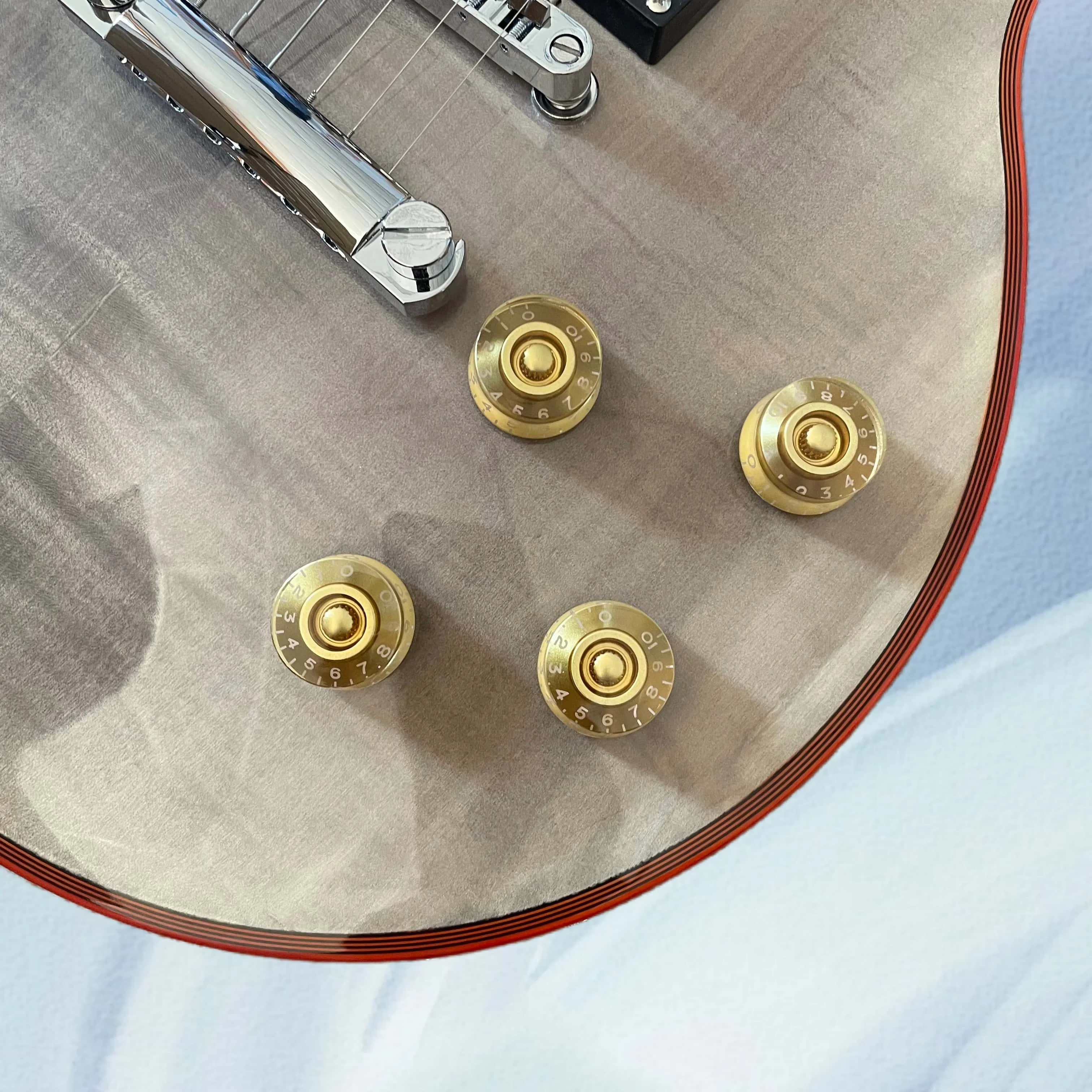 Transparent black electric guitar with red binding, chrome hardware, and a rosewood fingerboard