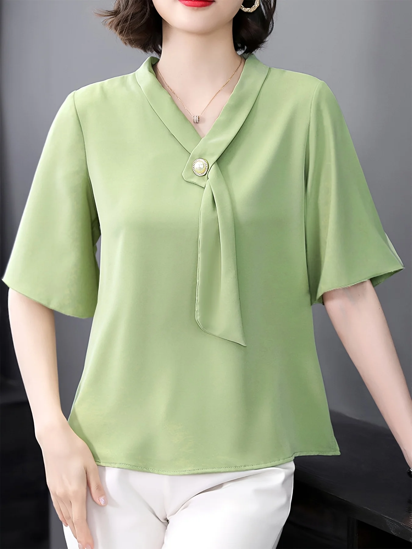 

Solid color ribbon V-neck mid sleeved shirt with pearl button decoration, loose fitting flesh blocking green women's top