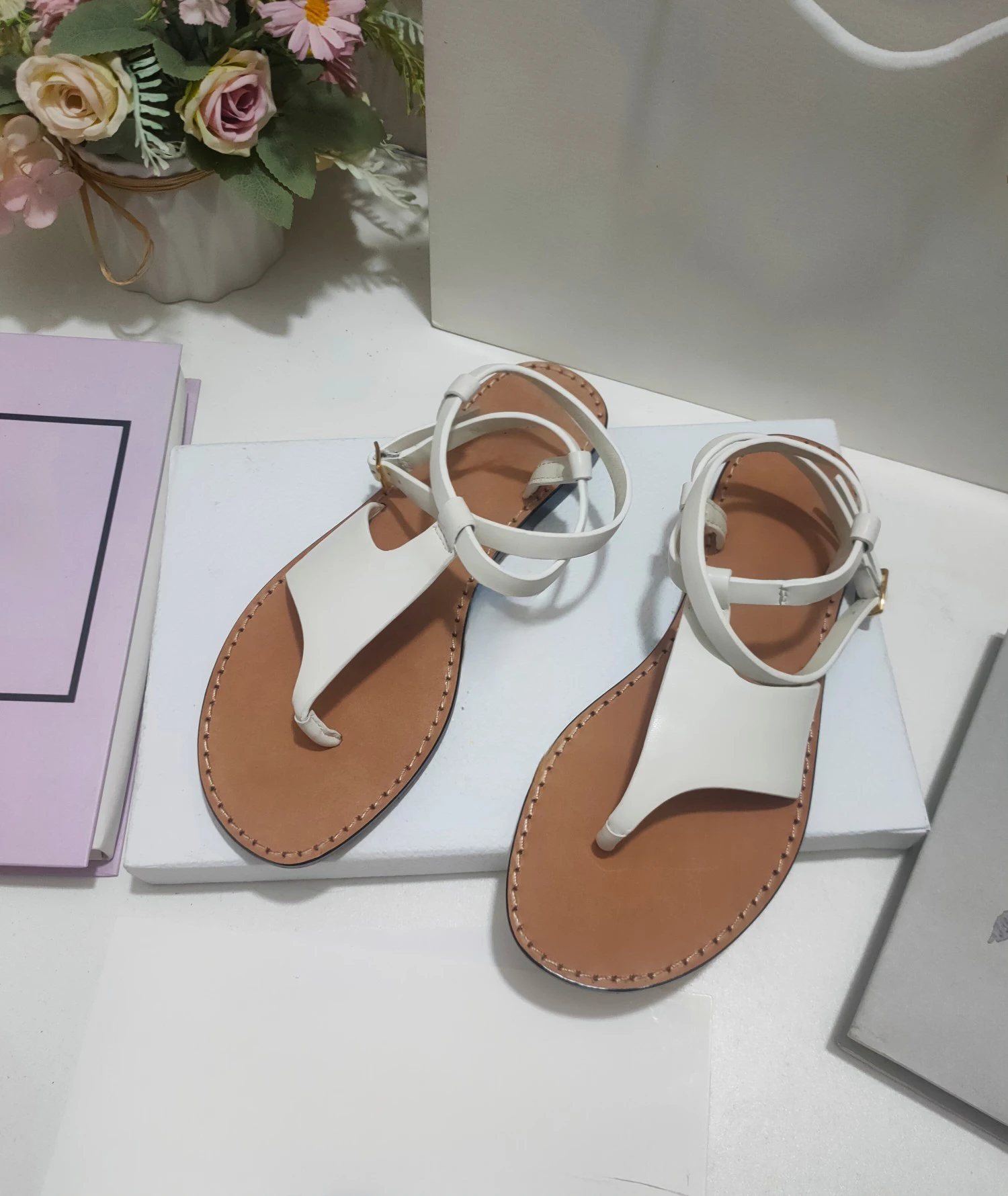 New clip-on sandals with asymmetric cowhide leather upper with adjustable buckle strap, highlighting the ankle line and design.