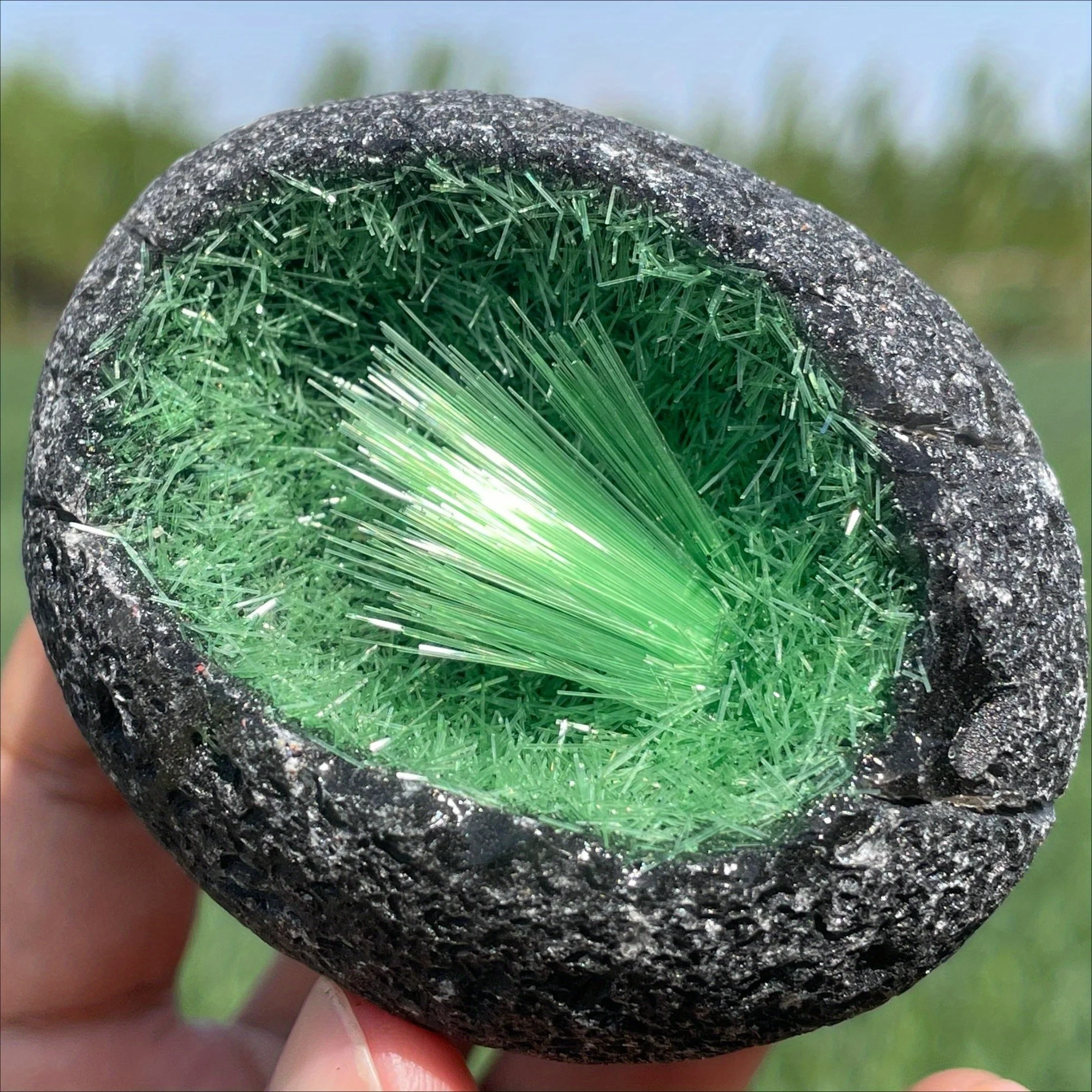 Un espécimen mineral en bruto, en forma de huevo, de magnetita verde y racimos de cristal de cuarzo, que contienen goetita y cristales de hielo.