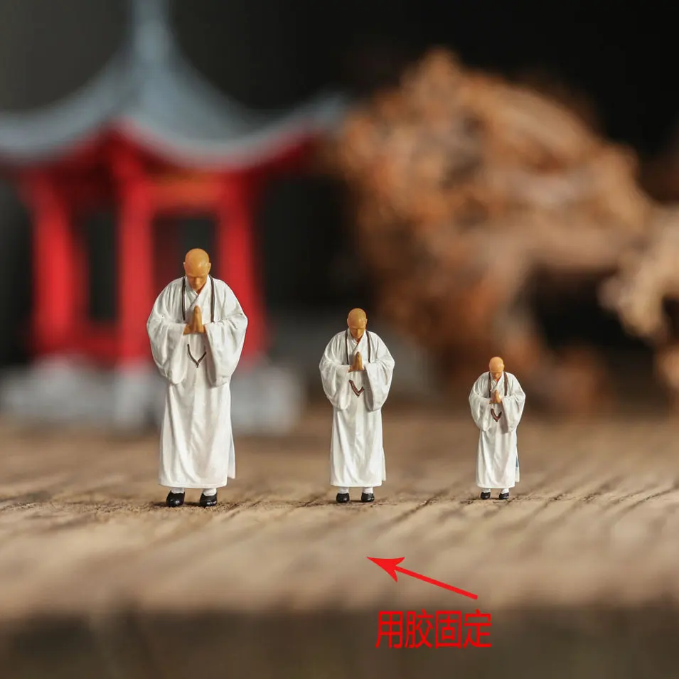 A small-scale, ancient-style figure, flower and bonsai miniature landscape model of a monk worshipping Buddha