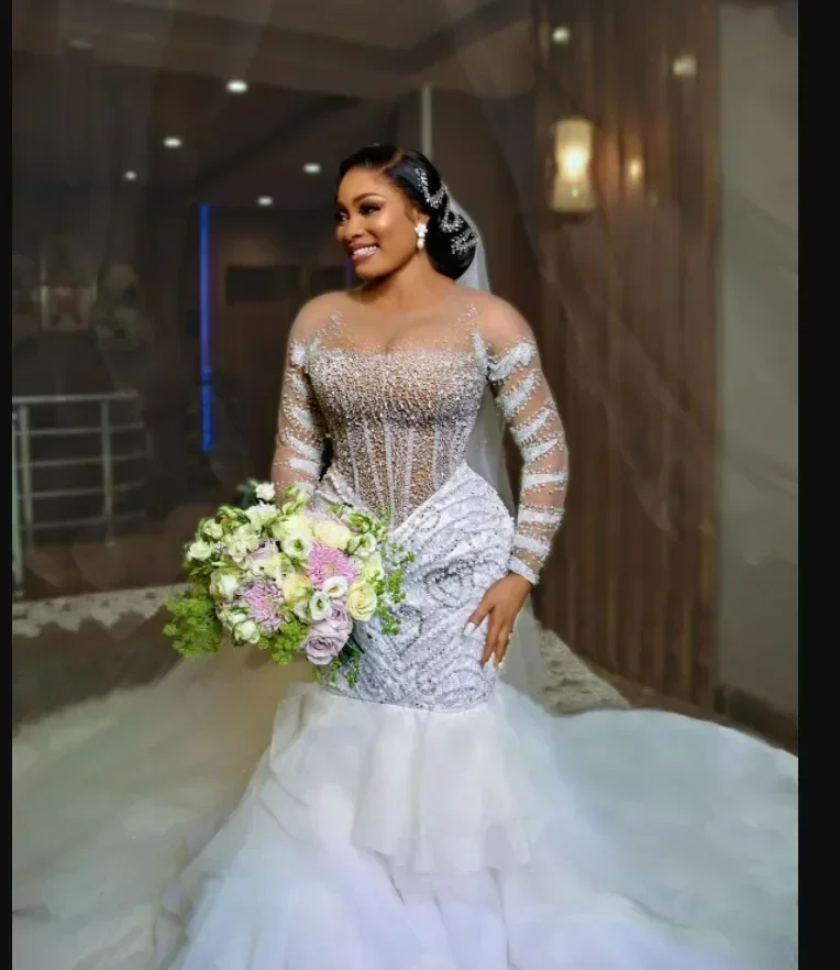 Maßgeschneidertes, sexy, durchsichtiges, mit Perlen besetztes, afrikanisches Brautkleid mit langen Ärmeln, kaskadierenden Rüschen und Hochzeitskleid in Übergröße